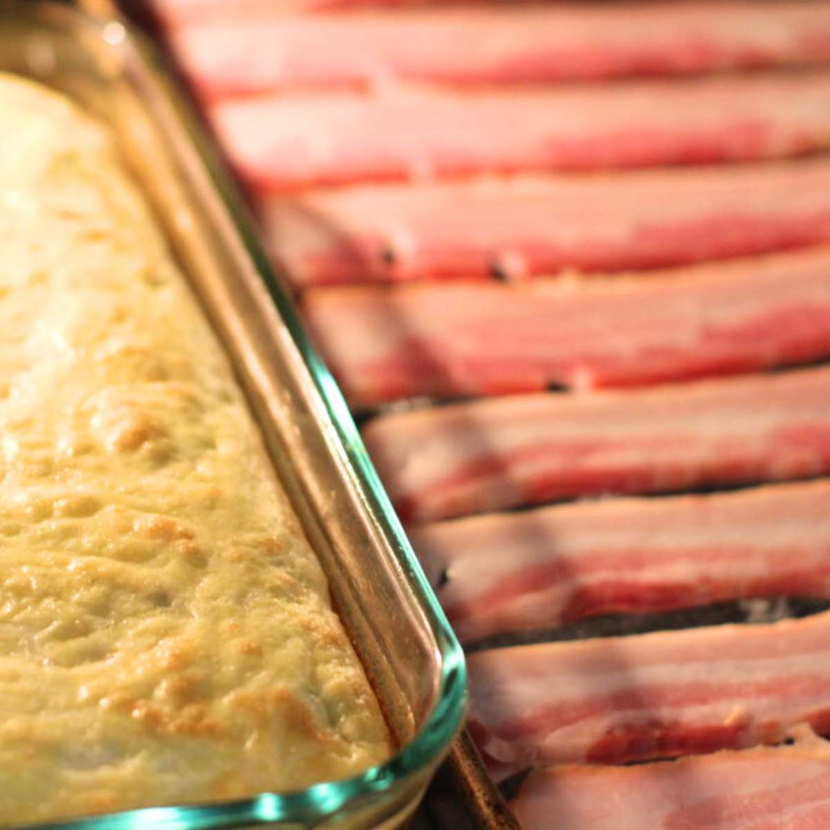 The green Chile egg casserole and bacon are baking inside an oven. 