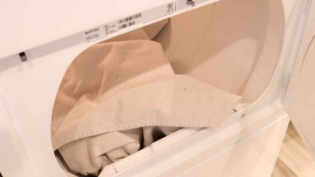 The freshly washed canvas fabric sitting in a white dryer after it has been fully dried. 