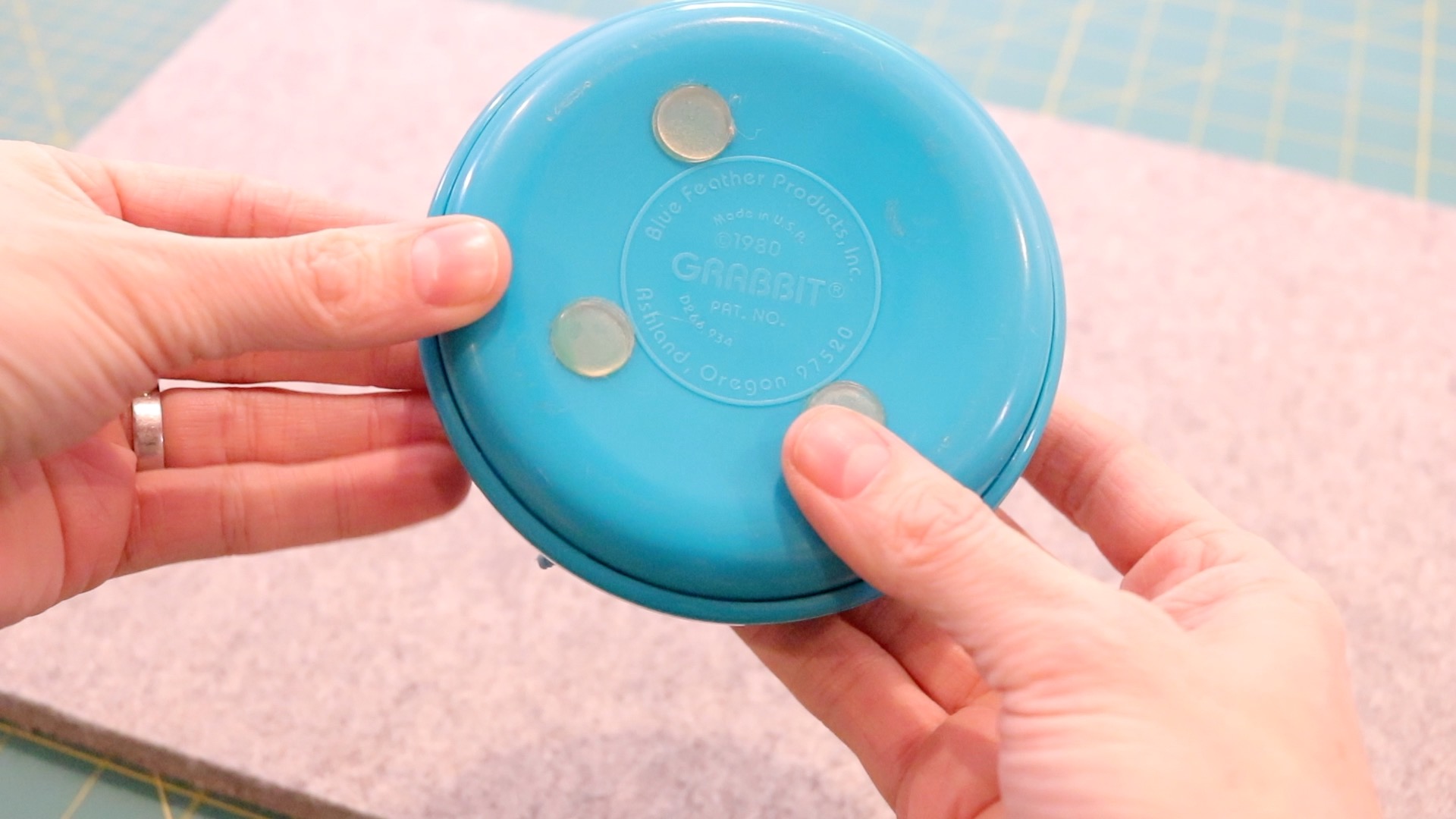 The bottom of the turquoise magnetic pin cushion with grips to keep it from sliding around on a sewing table.