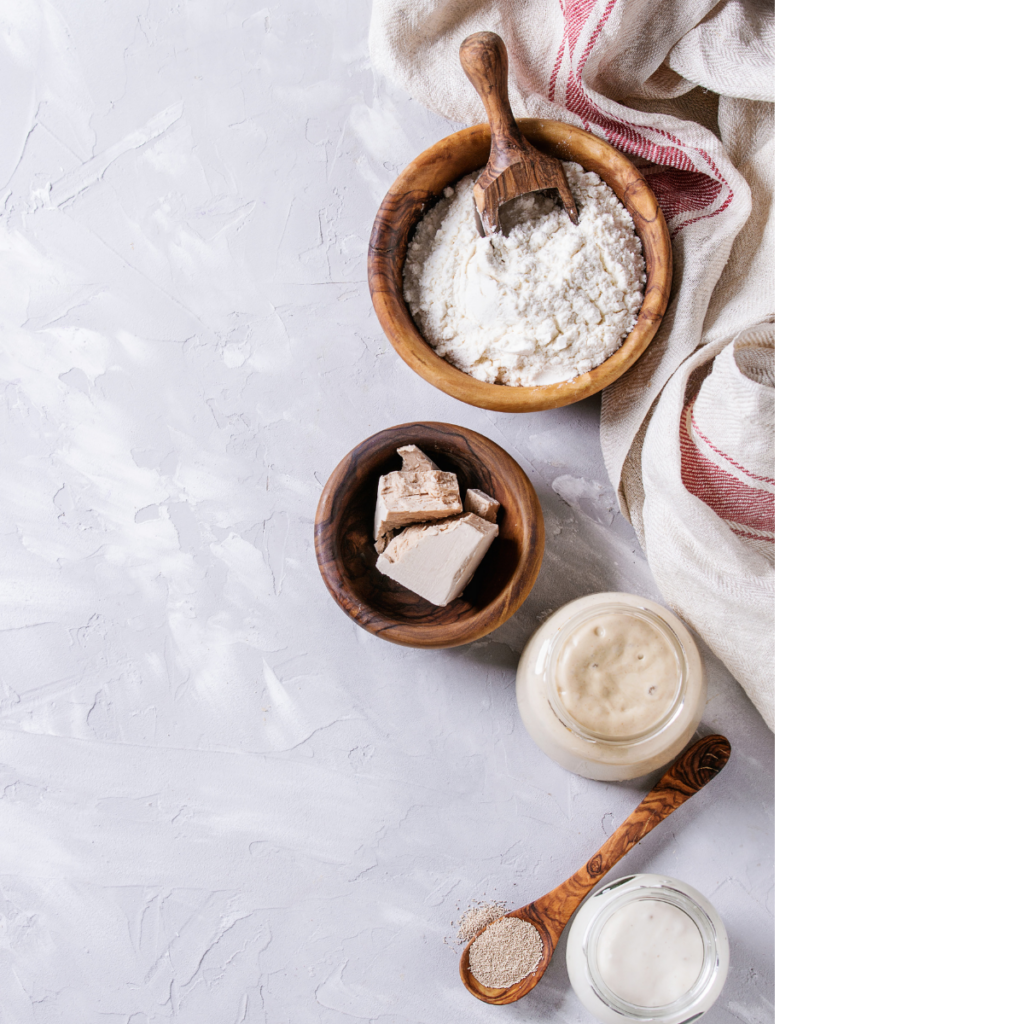 ingredients used to make a loaf of sourdough bread laid out on a table top. 