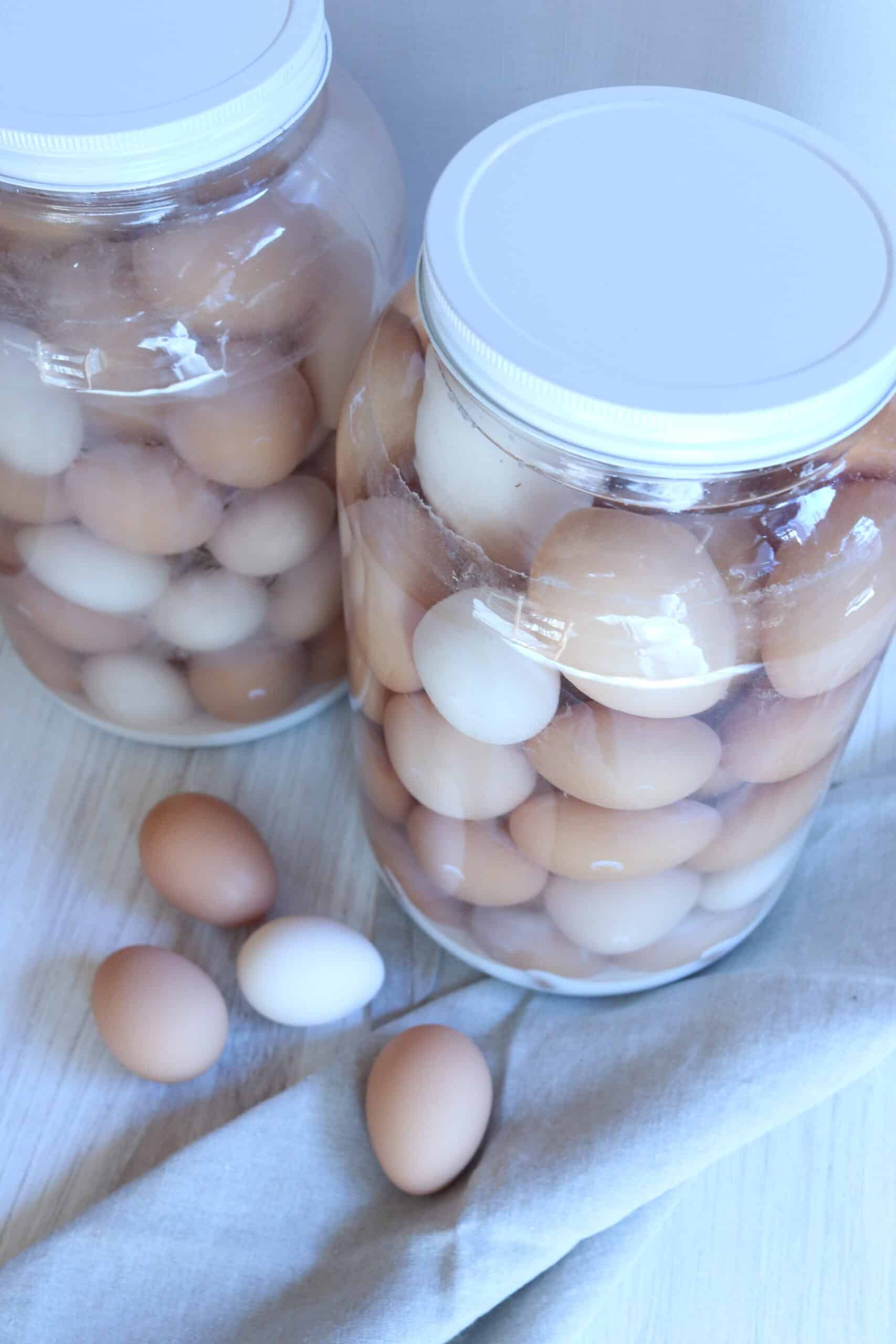 A picture of two large glass jars holding a variety of water glassed eggs.