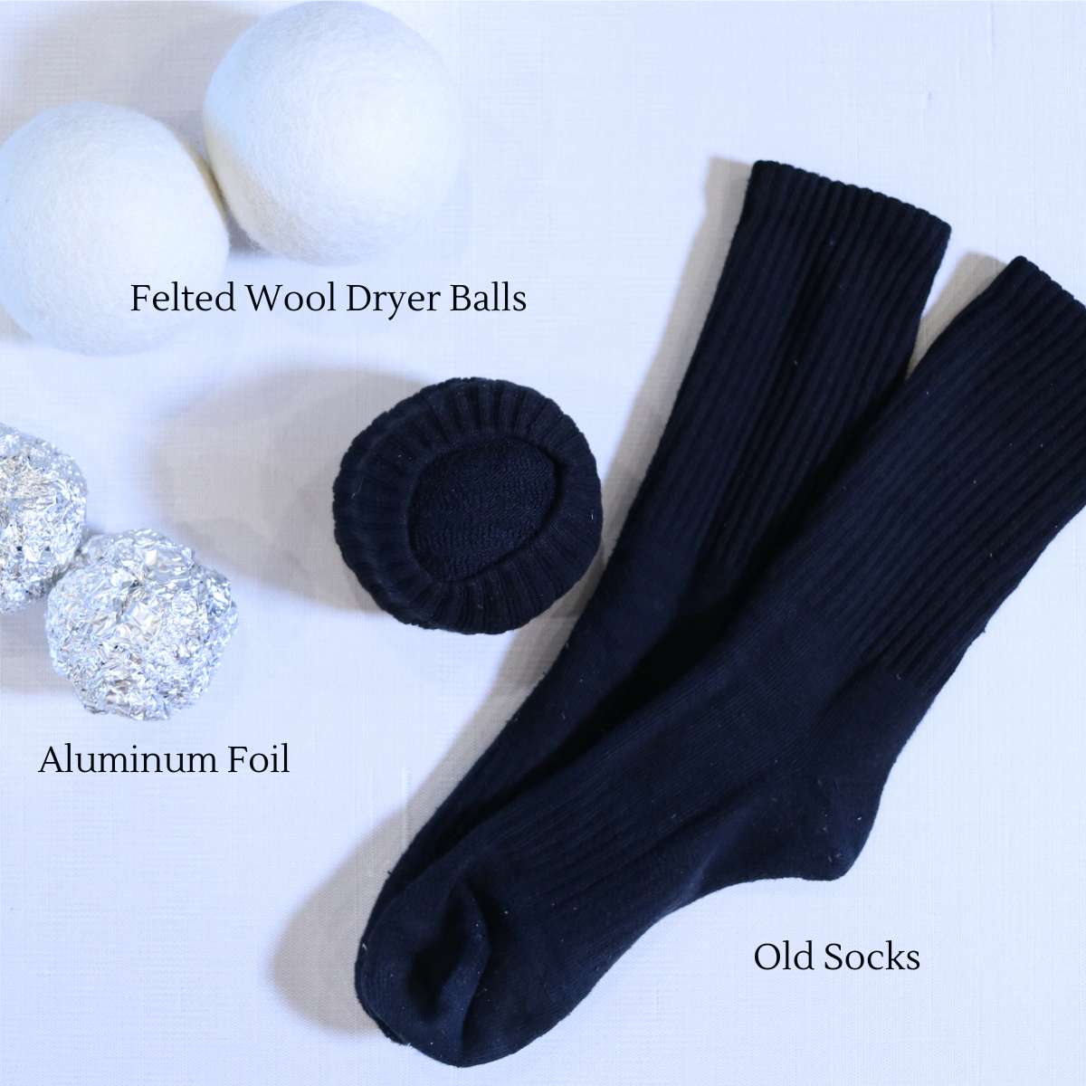 A picture showing three other dryer sheet alternatives. The pictures includes two white wool dryer balls, two balls of aluminum foil, and a pair of black socks next to a black ball of socks. All three options can be used in place of conventional dryer sheets.